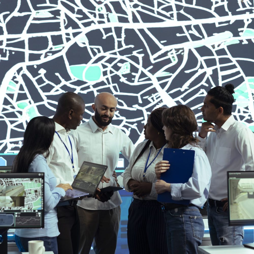 Diverse team of operators analyzing parcel awb and logistics to ensure order tracking service within the delivery app. Employee following truck drivers via gps coordinates on digital map.