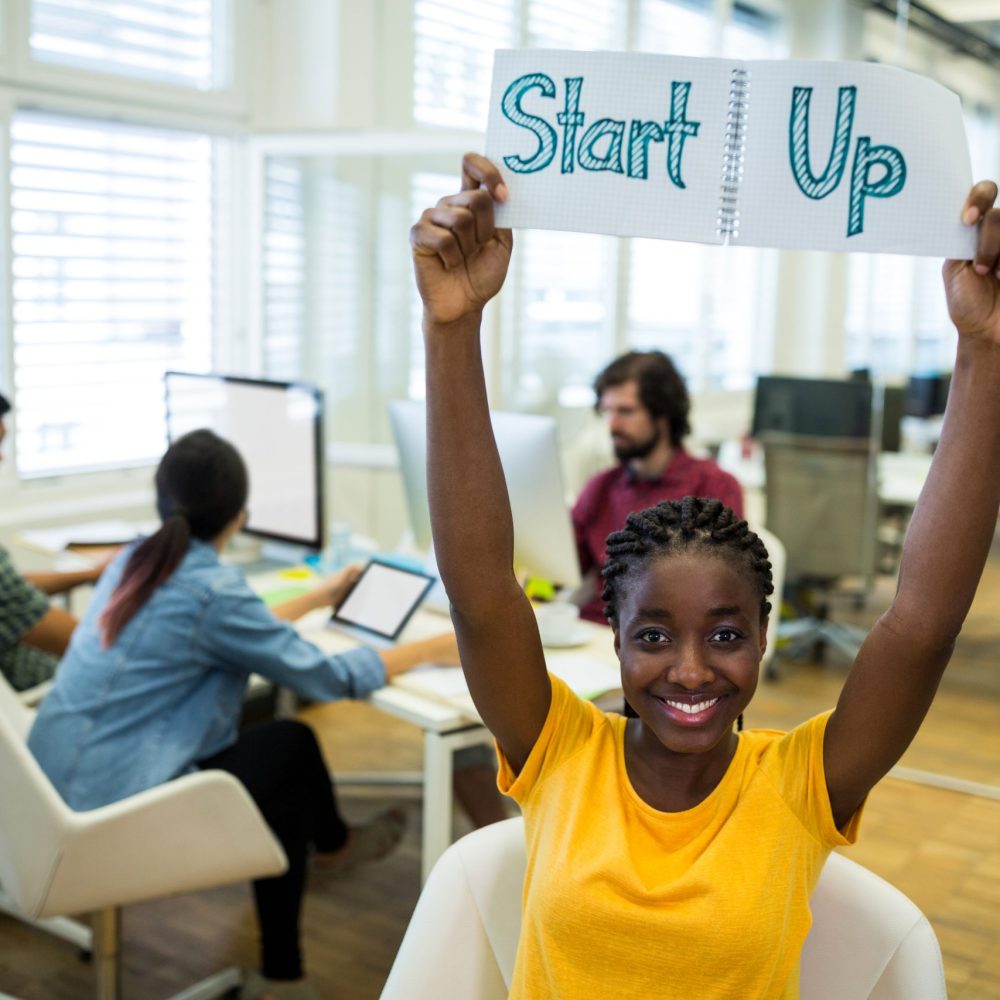 Portrait of female business executive start up sign in office